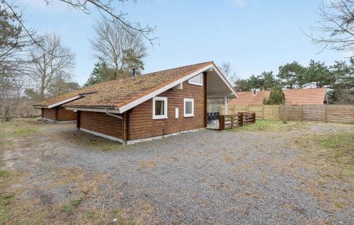 a small wooden house with a fence in a yard at Lovely Home In Nykøbing Sj With Sauna in Nyrup