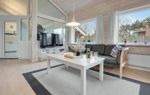 a living room with a white table and a tv at Lovely Home In Nykøbing Sj With Sauna in Nyrup
