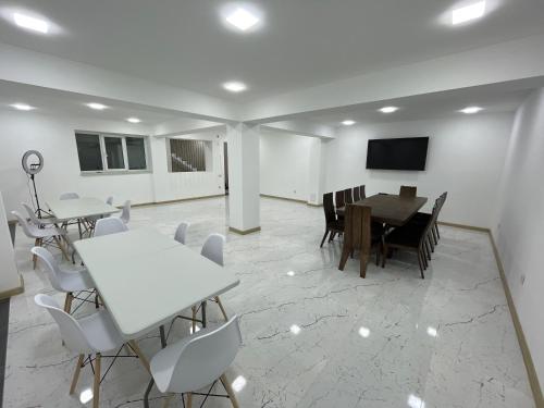 a dining room with tables and chairs and a tv at Dream home in Vanadzor