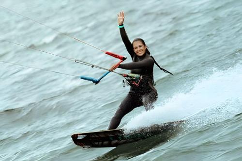 a woman on a surfboard in the water at Club Cean in Madroñal