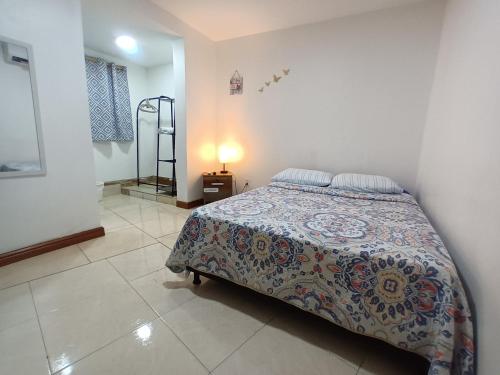a bedroom with a bed and a lamp on a tiled floor at Confortable y Central Habitación a 1 cuadra de la playa in San Andrés