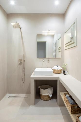 un bagno bianco con lavandino e doccia di Themis Homes a Skiros