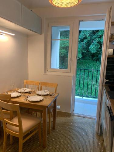 une salle à manger avec une table et des chaises et une fenêtre dans l'établissement Family apartment with parking Metro line 9, à Sèvres