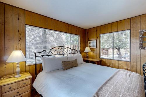 a bedroom with a white bed and two windows at On Timbered Time in Munds Park