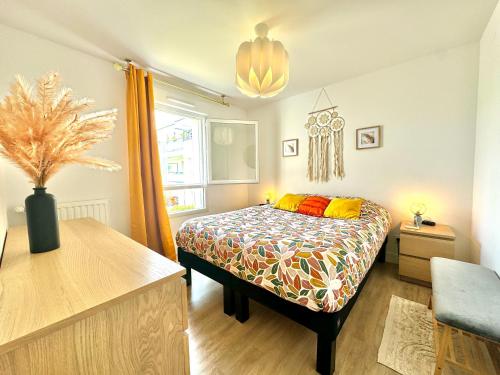 a bedroom with a bed with a colorful bedspread at L'atelier Chic - Wifi fibre - Parking privée - Balcon - NETFLIX in Lanester