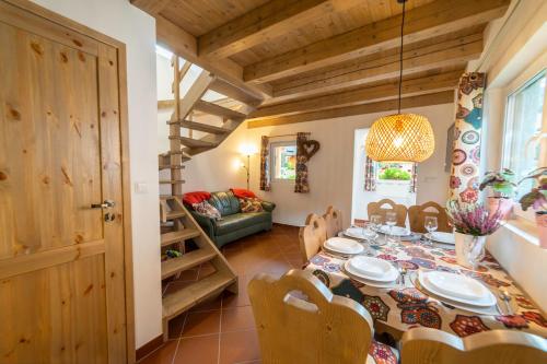 a dining room with a table and chairs and a couch at Mała Osada domki z jacuzzi przy gondoli in Szczyrk
