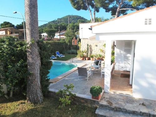 a villa with a swimming pool and a house at Landhaus mit Garten, Sonnenterrasse sowie überdachter Terrasse und Pool in Strandnähe in Cala Ratjada