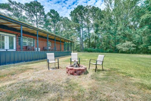 two chairs and a fire pit in front of a house at Secluded Broken Bow Cabin with Fishing Pond and Views! in Broken Bow