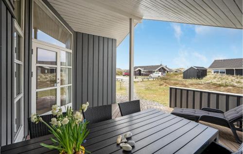 a porch with a table and chairs and a window at Pet Friendly Home In Hvide Sande in Bjerregård