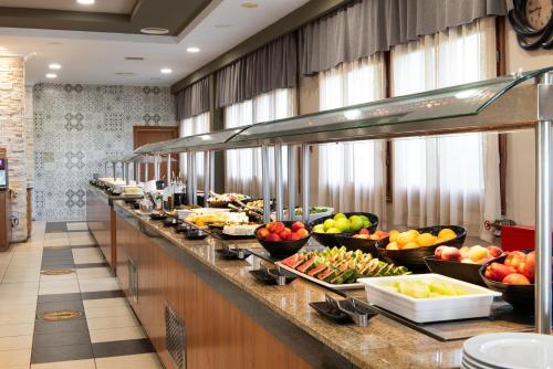 a buffet line with bowls of fruits and vegetables at Alexandros Palace in Ouranoupoli