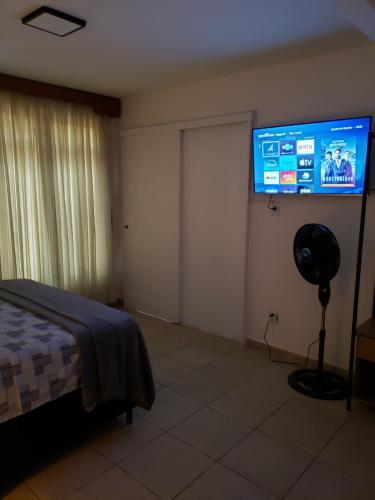 a bedroom with a flat screen tv on the wall at Pousada Monte Gerizim in Sao Paulo