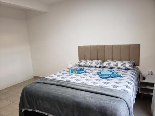 a bedroom with a bed with two blue bags on it at Pousada Monte Gerizim in Sao Paulo