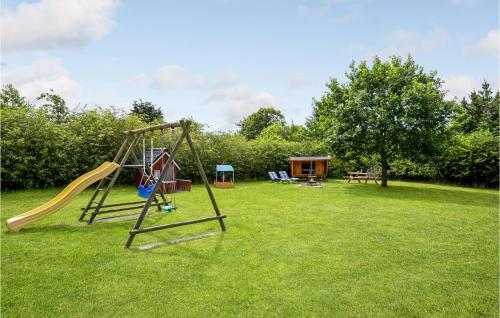 a playground with a slide in the grass at Holiday Home Sydskrænten Oksbøl Ix in Oksbøl
