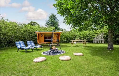 a play area with a swing and two chairs and a playground at Holiday Home Sydskrænten Oksbøl Ix in Oksbøl