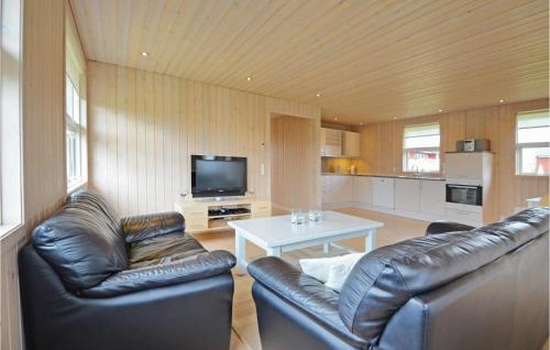 a living room with two leather couches and a television at Holiday Home Strandlyst Vinderup Vi in Vinderup