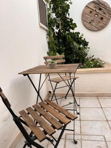 a wooden table and a chair next to a plant at Nonna Annunziata in Gemini