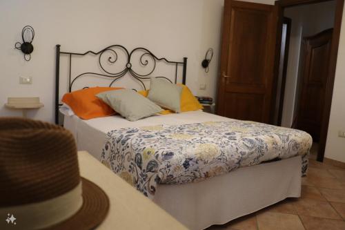 a bedroom with a bed with a hat on a table at Appartamenti Gli Ulivi Di Maremma in Gavorrano