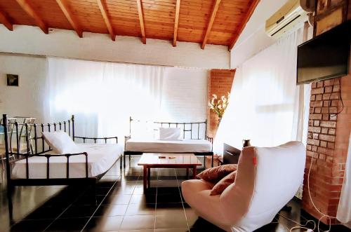 a living room with a couch and chairs and a window at Polyxeni Apartments & Rooms in Qeparo