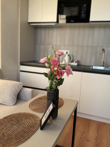 a vase of flowers sitting on a table in a kitchen at Apart Hotel Acropolis in Odesa