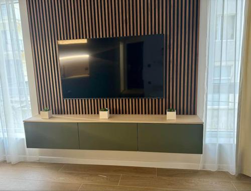 a television sitting on a shelf in a room at South Beach Apartment Primorsko in Primorsko