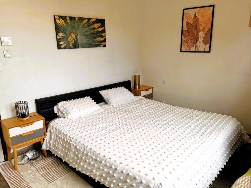 une chambre avec un lit et deux tableaux au mur dans l'établissement L Oiseau du Paradis, à Les Sables-dʼOlonne