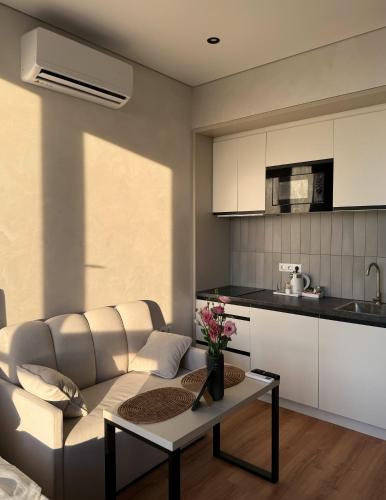a living room with a couch and a table at Apart Hotel Acropolis in Odesa