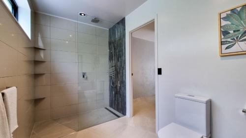 a shower with a glass door in a bathroom at Pacific Palms Luxury Villa in Rarotonga