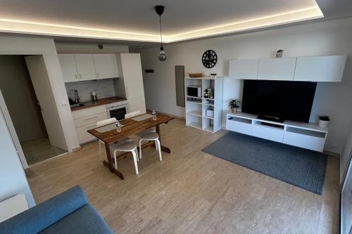 un salon avec une table en bois et une télévision dans l'établissement Studio Juan-les-Pins à 50m plage, à Antibes