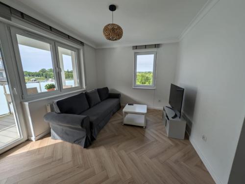 a living room with a couch and a tv at Komfort & Wodna Dolina in Koszalin