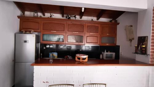 a kitchen with wooden cabinets and a refrigerator at Polyxeni Apartments & Rooms in Qeparo