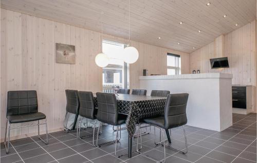 a dining room with a table and chairs at Four-Bedroom Holiday Home In Lokken in Løkken