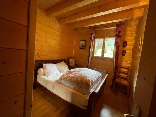 a bedroom with a bed in a log cabin at Chalet spacieux avec garage privé, animaux acceptés, terrasse et jardin, idéal pour familles ! - FR-1-692-101 in Abondance