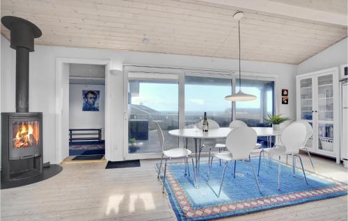 comedor con mesa y chimenea en Two-Bedroom Accommodation In Hjorring, en Vester Vidstrup