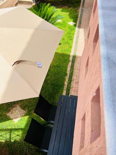 a white umbrella sitting on the grass next to a building at Carpe Diem Apartments in Psakoudia