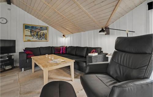 a living room with a couch and a table at Holiday Home Ringvejen X in Lakolk