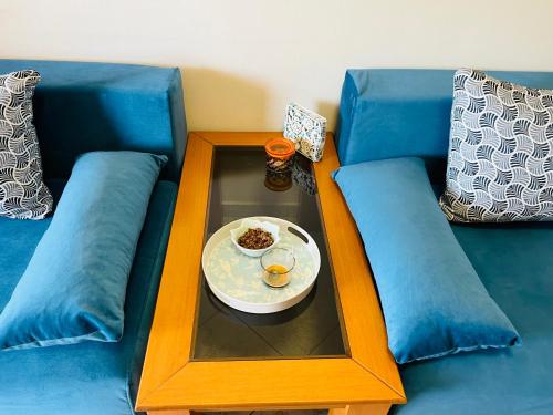 a table with a plate of food on a blue couch at Carpe Diem Apartments in Psakoudia