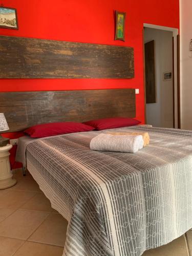 a bedroom with a large bed with a red wall at n CELI in Uggiano la Chiesa