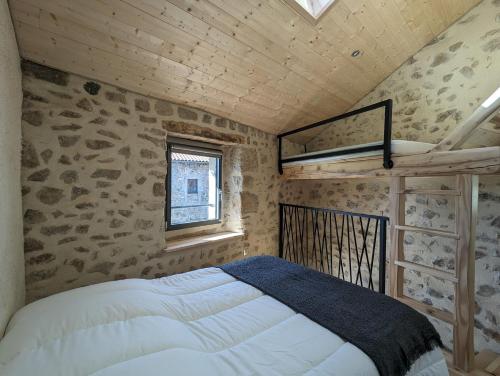 une chambre avec un lit dans un grenier dans l'établissement La ptite maison, à Chaspinhac