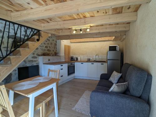 une cuisine et un salon avec une table et un canapé dans l'établissement La ptite maison, à Chaspinhac