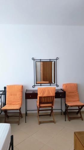 two chairs and a desk with a mirror on a wall at Polyxeni Apartments & Rooms in Qeparo