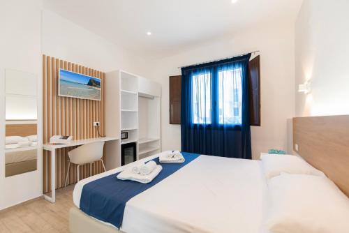 a bedroom with a bed and a desk and a window at Room 86 in San Vito lo Capo