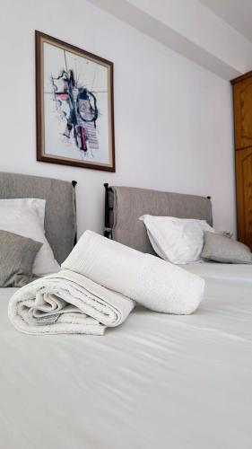 a white blanket sitting on top of a bed at Polyxeni Apartments & Rooms in Qeparo