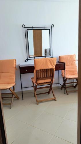 a dressing table with two chairs and a mirror at Polyxeni Apartments & Rooms in Qeparo