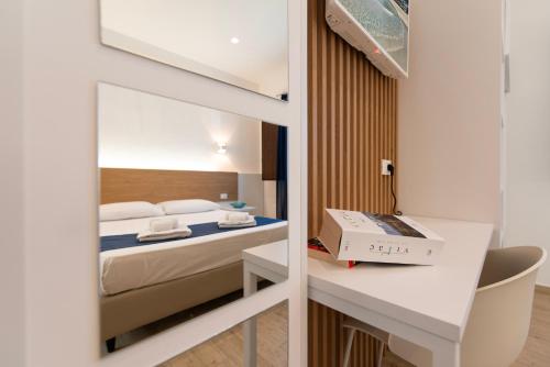 a bedroom with a bed and a desk with a box on it at Room 86 in San Vito lo Capo