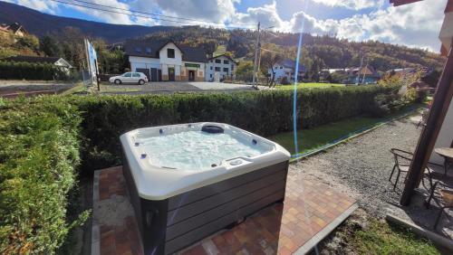 a hot tub sitting on the side of a yard at Mała Osada domki z jacuzzi przy gondoli in Szczyrk