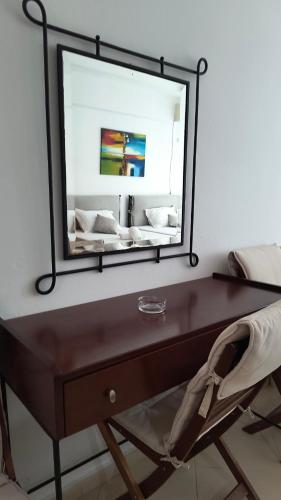 a mirror on top of a desk with a chair at Polyxeni Apartments & Rooms in Qeparo