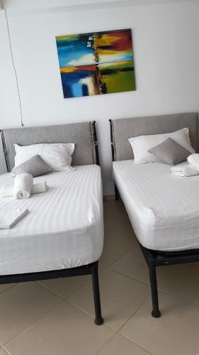 two beds sitting next to each other in a room at Polyxeni Apartments & Rooms in Qeparo