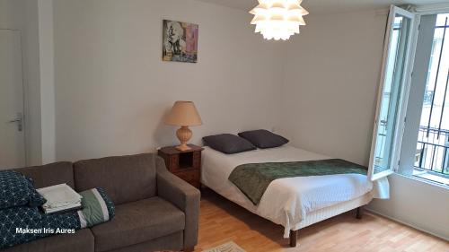 un salon avec un lit et un canapé dans l'établissement Appartement proche du moulin rouge et de la gare Saint Lazare et des grands magasins galeries Lafayette, à Paris