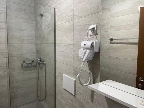 a bathroom with a shower with a phone on the wall at Hotel Majestic in Struga