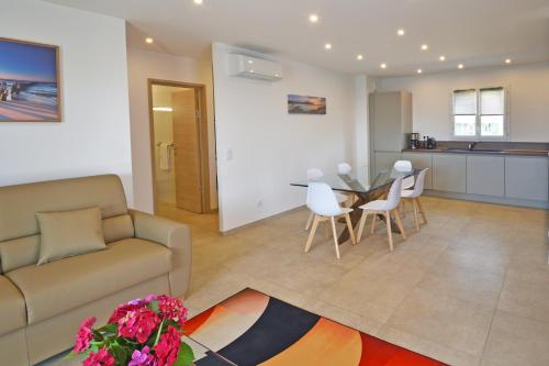 a living room with a couch and a table and chairs at Résidence Saint-Jean in Saint-Florent